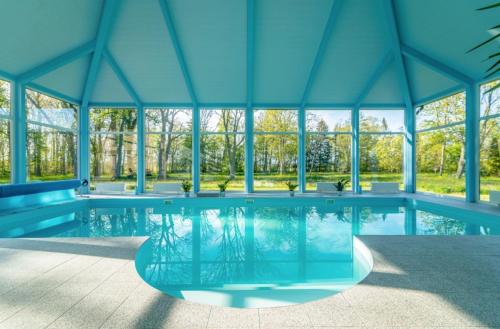 - une piscine dans un pavillon doté de plafonds bleus dans l'établissement Ziemupes Muiža & SPA, à Ziemupe