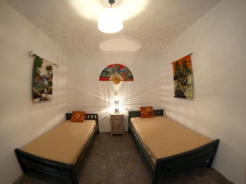 Zimmer mit 2 Betten und einer Lampe in der Unterkunft LUXURIUS VILA LICHADA in Likhás