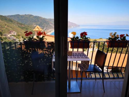 a balcony with a table and a view of the ocean at Athena Charming Rooms in Taormina