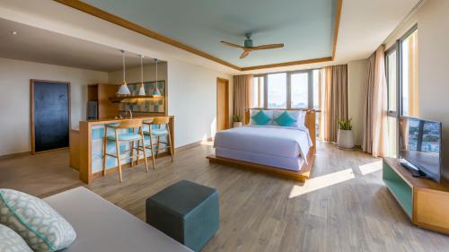 a bedroom with a bed and a living room at Fusion Suites Vung Tau in Vung Tau
