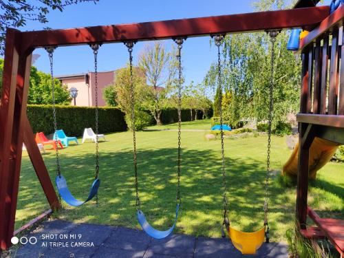 a swing set in a yard with a playground at Hotel Graffit in Świebodzin