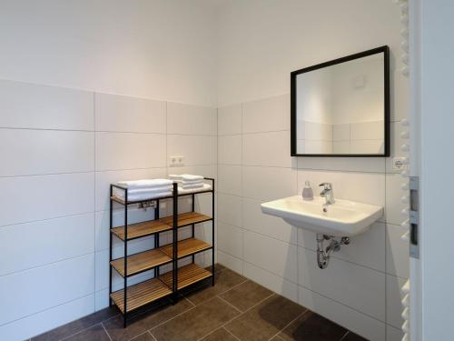 a bathroom with a sink and a mirror at Travel Art Boardinghouse in Neuruppin