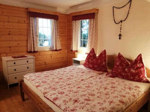 a bedroom with a bed with red pillows at Hof Zaunfranzl in Stubenberg