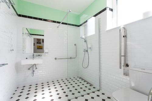 a white bathroom with a shower and a toilet at Motel Eldorado in Mikulov