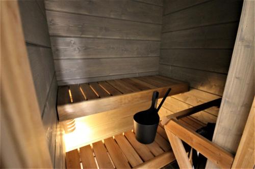 una sauna de madera con una olla negra. en Forenom Aparthotel Kuopio en Kuopio