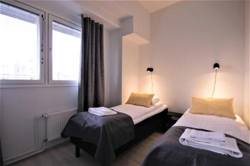 2 camas en una habitación con 2 ventanas en Forenom Aparthotel Kuopio en Kuopio