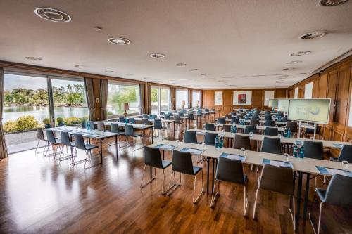 a conference room with tables and chairs and a screen at Best Western Premier Seehotel Krautkrämer in Münster