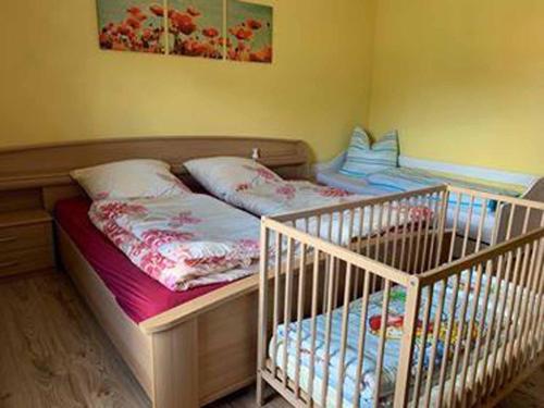 two twin beds in a room with a crib at Ferienwohnung Fuchsbau in Konzell