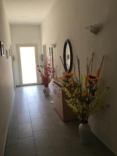 a bathroom with a sink and a mirror and flowers at Casa jole in Assemini