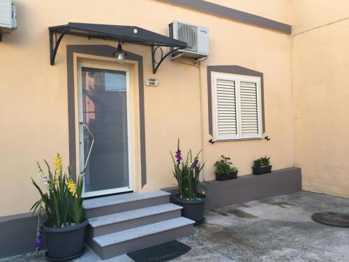 a house with stairs and potted plants on it at Casa jole in Assemini