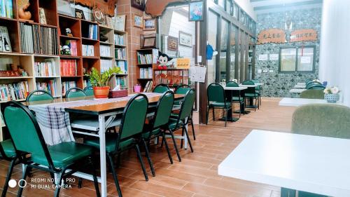 大同区太平山-部落山莊景觀民宿的图书馆配有绿色椅子、桌子和书架