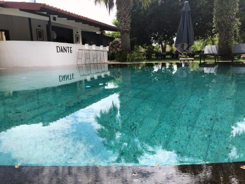 a swimming pool with blue water and an umbrella at Murat Pasha Mansion in Dalyan
