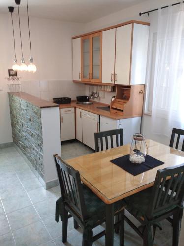 a kitchen with a wooden table and chairs in it at Veky in Jezera