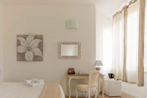 a bedroom with a bed and a desk and a mirror at Affittacamere Casa Dane' in La Spezia