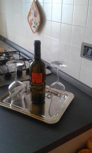 a bottle of wine sitting on a tray next to two wine glasses at Una Finestra sul Mare - Free Wi -Fi in Riomaggiore