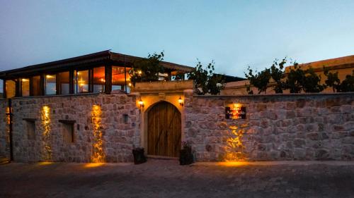 a building with a stone wall with a wooden door at Asyada Suites Hotel in Nevsehir