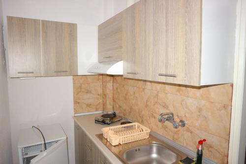 a kitchen with wooden cabinets and a sink at Edelweiss Studios in Limenas
