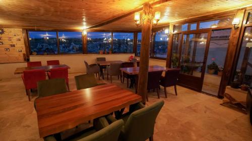 a restaurant with wooden tables and chairs and windows at Asyada Suites Hotel in Nevsehir