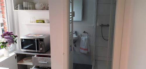 a small bathroom with a microwave and a shower at Ferienwohnung Wittenberge in Wittenberge
