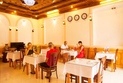 a group of people sitting at tables in a restaurant at Hoa Mau Don Homestay in Hoi An