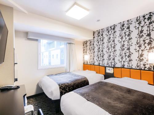 A bed or beds in a room at APA Hotel & Resort Yokohama Bay Tower