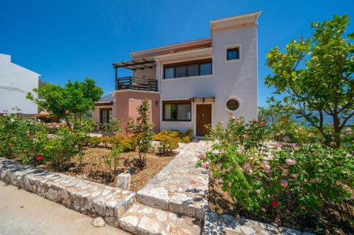 a house with a garden in front of it at Villa Kandia in Ayia Evfimia