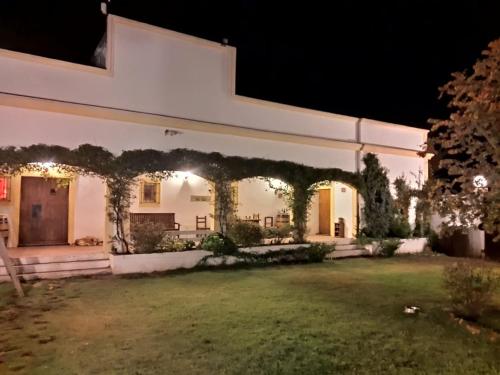 a house with an ivy covered facade at night at Finca La Penúltima-Posada in San Rafael