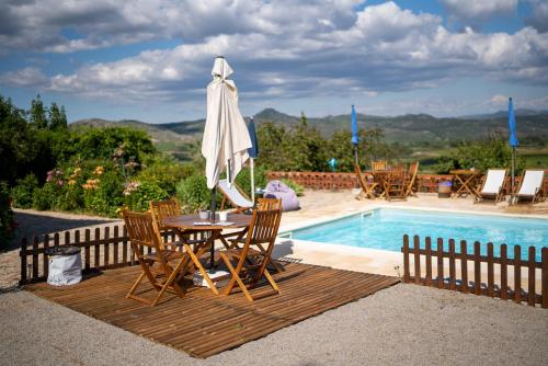 a table and chairs with an umbrella next to a pool at Quinta do Sol in Alijó