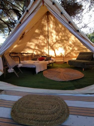 a white tent with two beds and two rugs at miCielo - Baumhäuser in Vejer de la Frontera