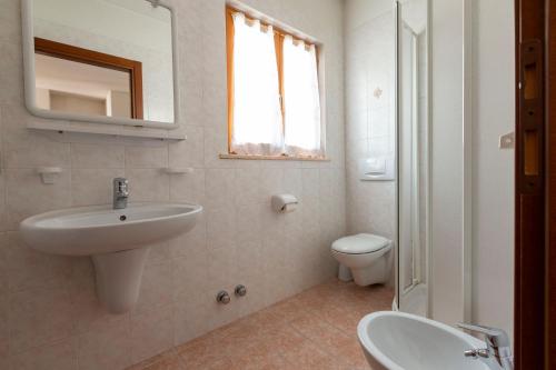 bagno bianco con lavandino e servizi igienici di Chalet Olta a Livigno