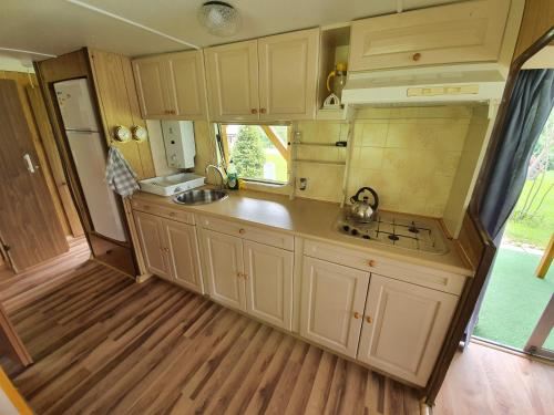 a kitchen with white cabinets and a sink at U Jędrusia in Polańczyk