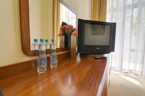 two bottles of water sitting on a table next to a television at Apartamenty Renesans in Krynica Zdrój
