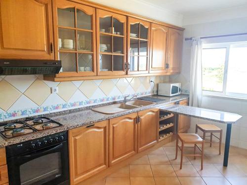 a kitchen with wooden cabinets and a counter top at Vilamoura, Marina Sol T1 in Quarteira