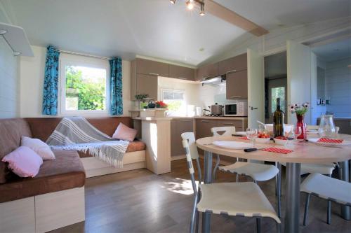 une cuisine et un salon avec une table et un canapé dans l'établissement SARL LE RELAIS DU MARAIS DOUX Camping Les Cercelles, à Dolus-d'Oléron