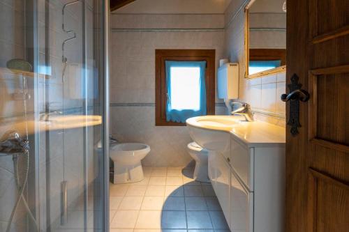 a bathroom with a toilet and a sink and a shower at Appartamento Emanuel in Livigno