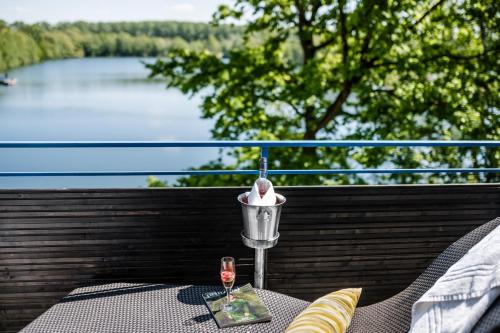 a table with a glass of wine on a balcony at Best Western Premier Seehotel Krautkrämer in Münster