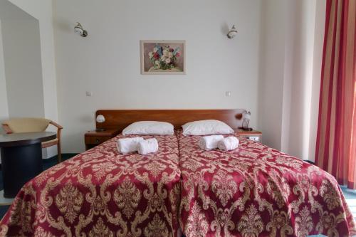 a bedroom with a red bed with two towels at Apartamenty Renesans in Krynica Zdrój