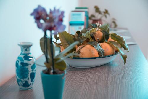 a bowl of plants on a table next to a vase at Nonna Carmelina in Ravello