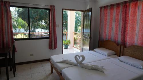 um quarto com 2 camas e uma grande janela em Wellbeach Dive Resort em Zamboanguita