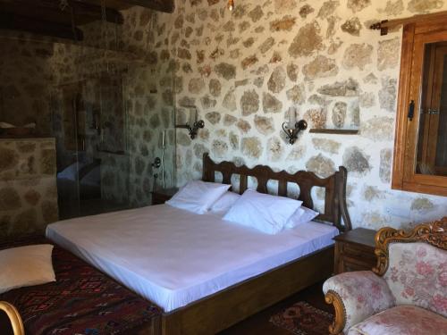 a bedroom with a bed in a stone wall at Beso Patara in Patara