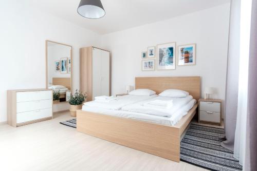 a bedroom with a large bed and two mirrors at Apartamenty Dune in Jastarnia