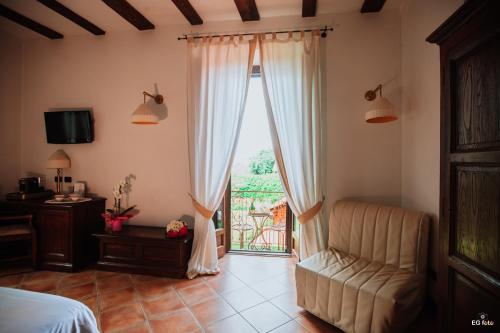 sypialnia z łóżkiem i przesuwnymi szklanymi drzwiami w obiekcie Al Castello Resort w mieście Sillavengo