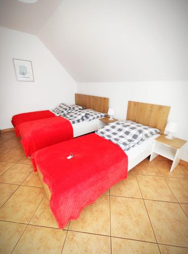 two beds sitting next to each other in a room at Willa Nord in Pustkowo