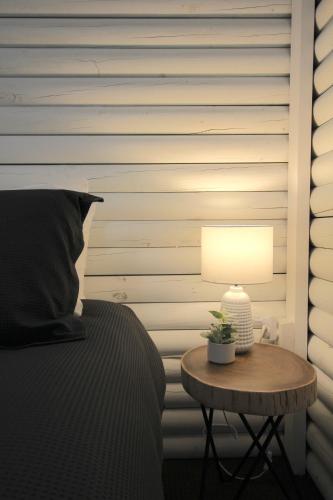 a bed with a table with a lamp on it at Palmers Lane Estate Hunter Valley in Pokolbin