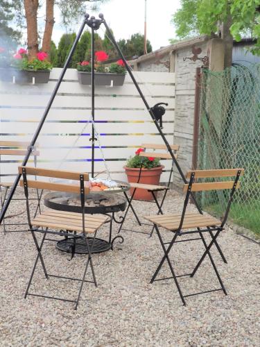 a swing set with two chairs and a grill at Willa Nord in Pustkowo