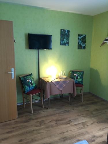 Zimmer mit einem Tisch, 2 Stühlen und einem TV in der Unterkunft Gasthaus Zum Stadtwald in Rottenmann