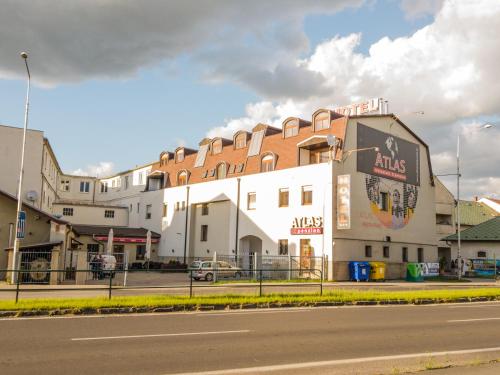 a large white building on the side of a street at Penzion Atlas in Liptovský Mikuláš