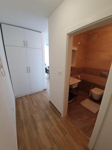 a room with a bathroom with a toilet and a door at Apartments Majic Zivogosce in Živogošće