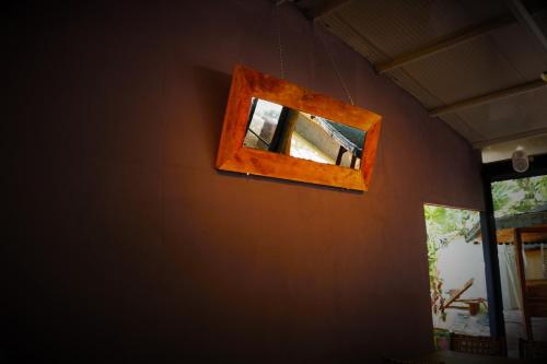 un espejo colgado en una pared junto a una ventana en Simge Pension, en Cıralı