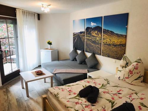 een woonkamer met een bed en een bank bij Appartement Eichhörnchen - zentral Todtmoos Schwarzwald Black Forest in Todtmoos